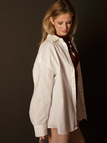 Dina Oversized Button Up with collared neckline, long sleeves, button front, button cuffs, chest pocket, oversized fit, and long length.
