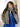 Model wearing an oversized colorblock faux-fur coat with a stand collar, zip-front closure, and long sleeves.