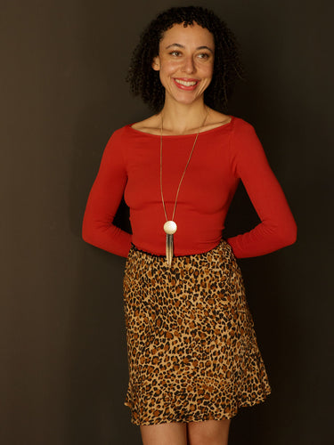 Model wearing a fitted ribbed long-sleeve top with a boat neckline and ultra-stretchy fabric.