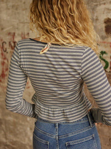 Striped long sleeve peplum top with square neck, functional snap buttons, cropped length, and stretchy lightweight fit.