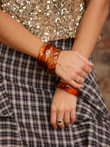 Acrylic amber swirl bangle available in round, square, or twist styles; sold individually.