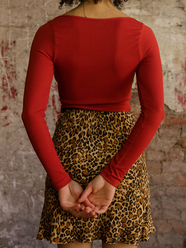 Model wearing a fitted ribbed long-sleeve top with a boat neckline and ultra-stretchy fabric.