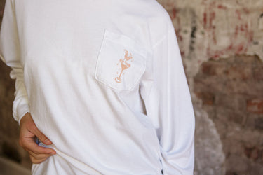 Model wearing a lightweight long-sleeve cotton top with a crew neckline, front chest pocket, and martini cowgirl print in a relaxed fit.