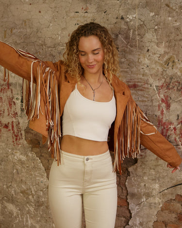 Cropped faux suede fringe jacket with lapel collar, long sleeves, lining, and stretch.