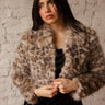 Cropped faux fur leopard coat with collar, long sleeves, and relaxed fit.