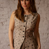 Long sleeveless vest with high neck, button-up front, dainty floral print, and fitted back with gold pin.