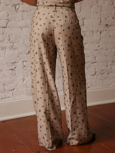 Mid-rise pleated pants with button and zipper closure, belt loops, front pockets, and dainty floral print.