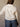 Cropped long sleeve button-up top with collared neckline, chest pocket, heart trim, and lightweight fabric.