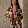Long-sleeve cow print button-up jacket with collar, chest pockets, button cuffs, lightweight fabric, and long length.