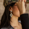 Silver or gold chandelier earrings with gem accents and post back closure.