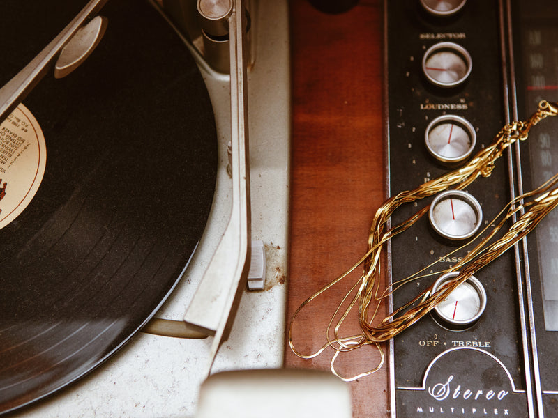 Record player with stack of necklaces.